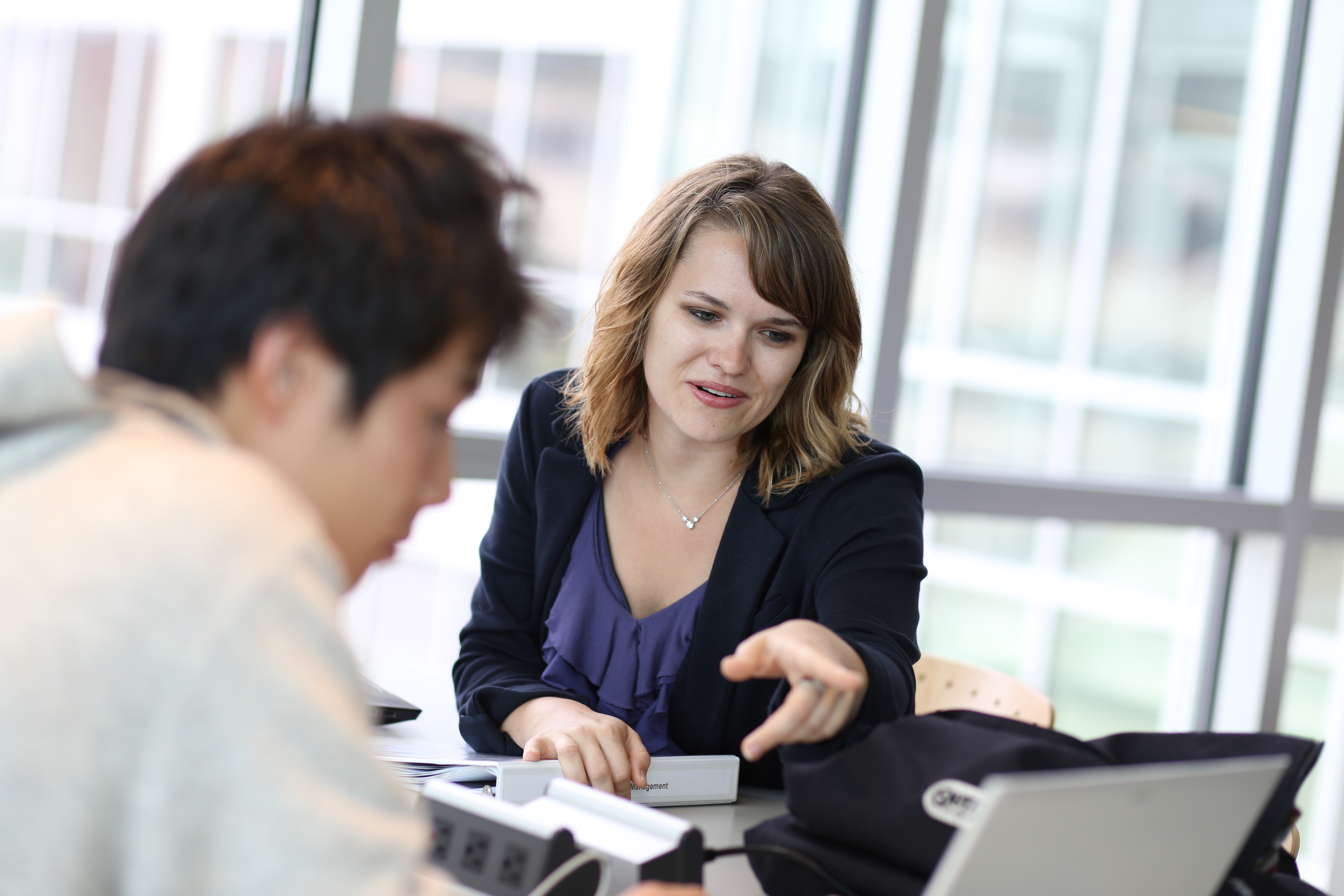 Advising with woman pointing to screen with student viewing computer