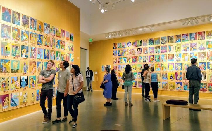 People viewing colorful art in an art exhibit
