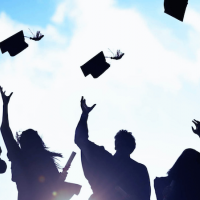 silhouette of graduates throwing their caps in the air