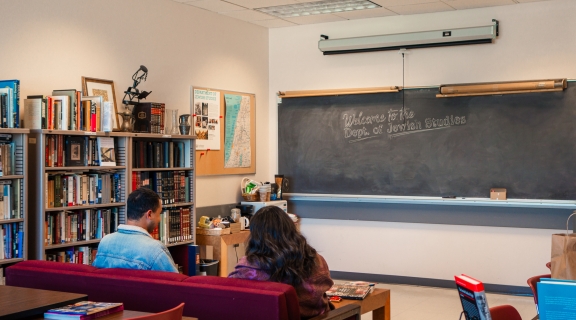 Two students lounging on the couch in the Jewish Studies Lounge
