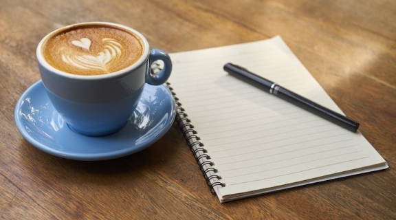 Coffee with a pen and a notebook